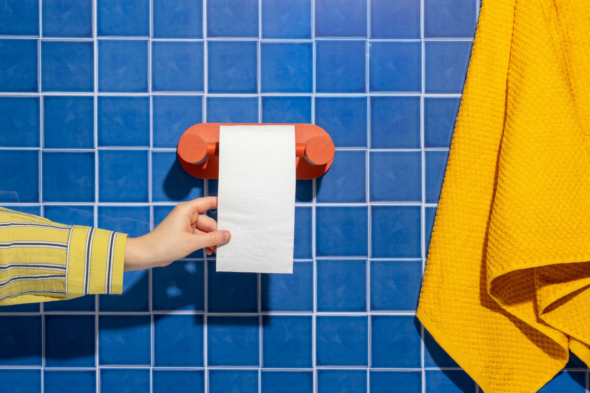 Roto toilet paper holder on wall showing front and side profile
