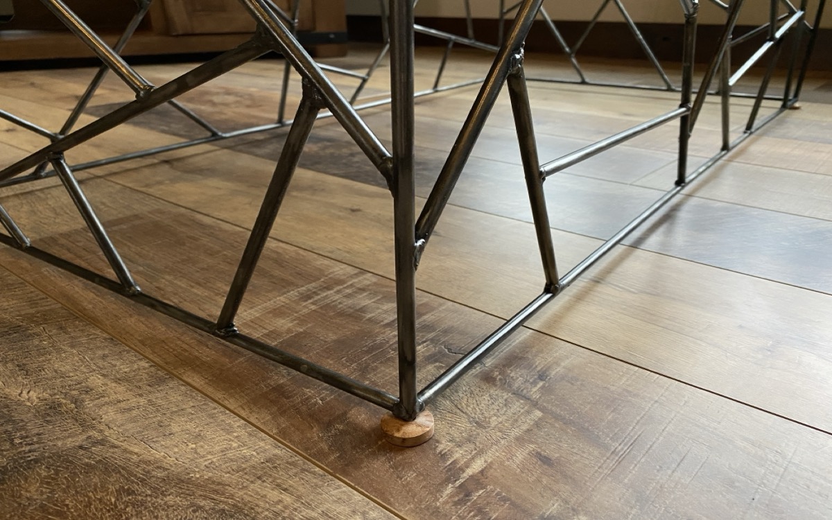 Close-up of the brazed rod joints at the base corner showing the lattice geometry