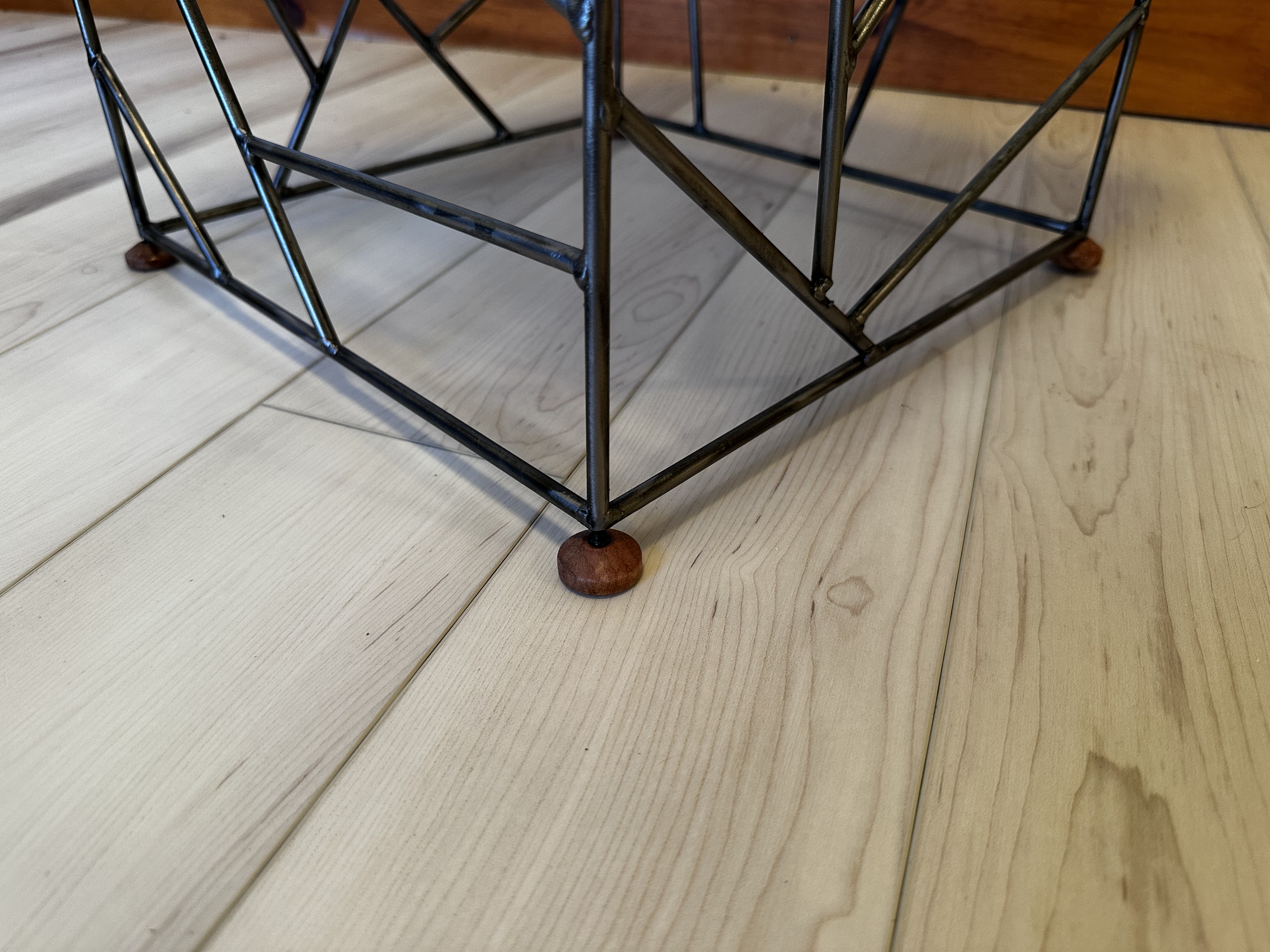 Close-up of the lathe-turned wood foot where the lattice meets the floor