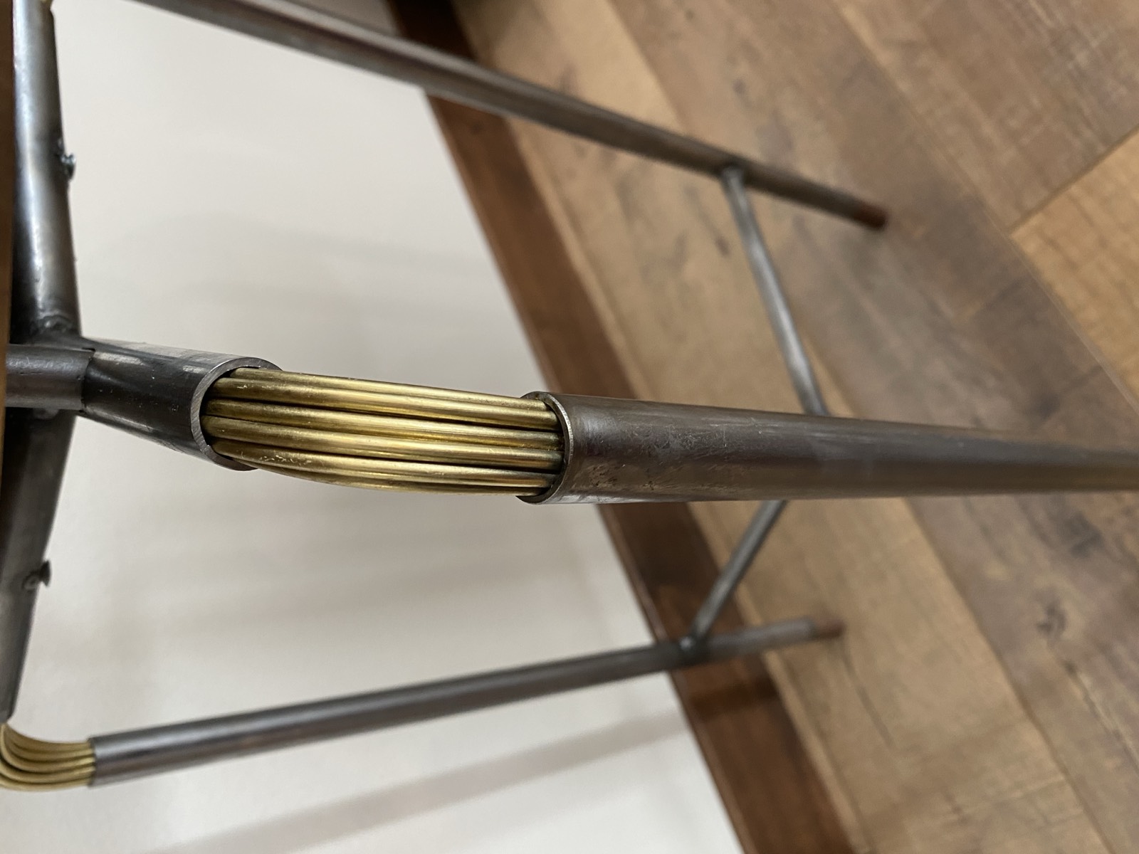 Close-up of the brass wire joinery technique — rods packed into the tube at the joint