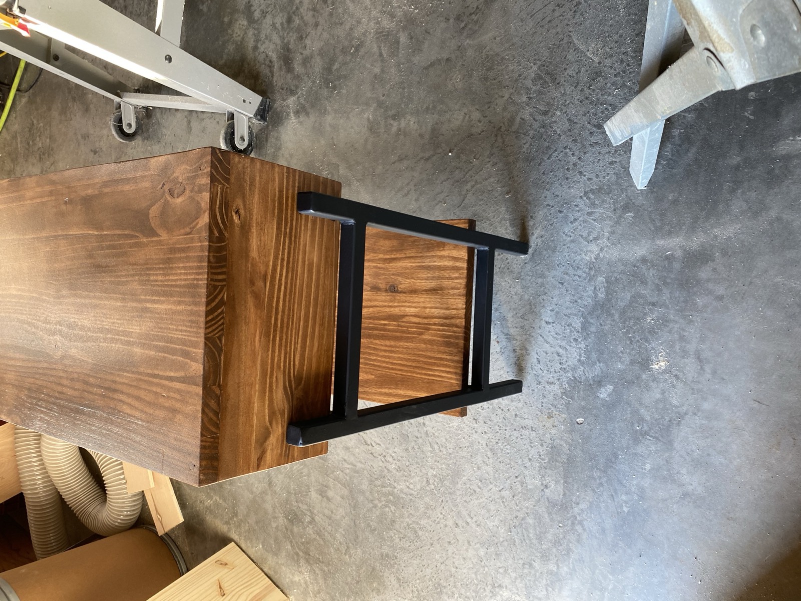 Side view showing the stained wood body on welded steel base