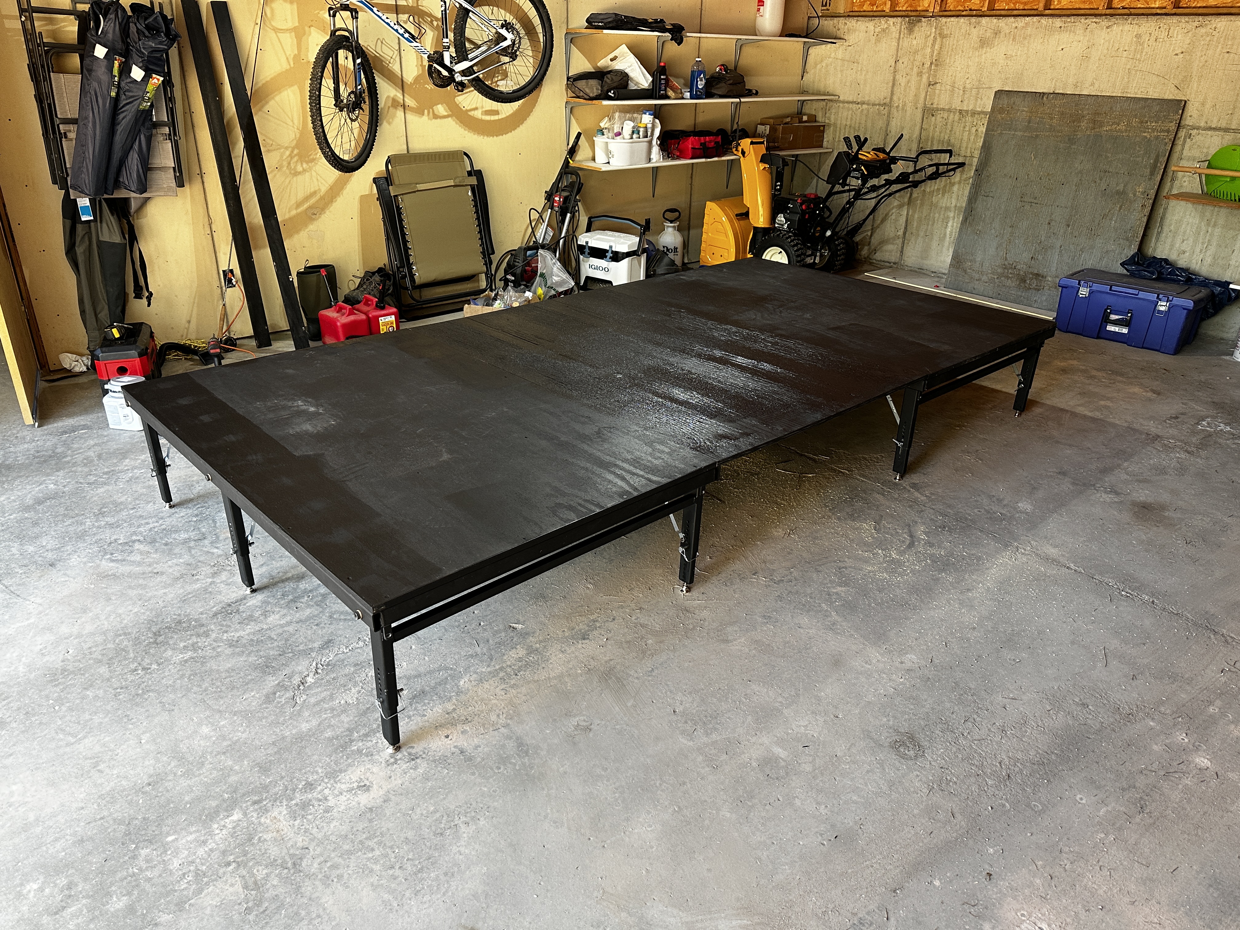 Full modular stage assembled in the garage showing all panels joined and legs deployed