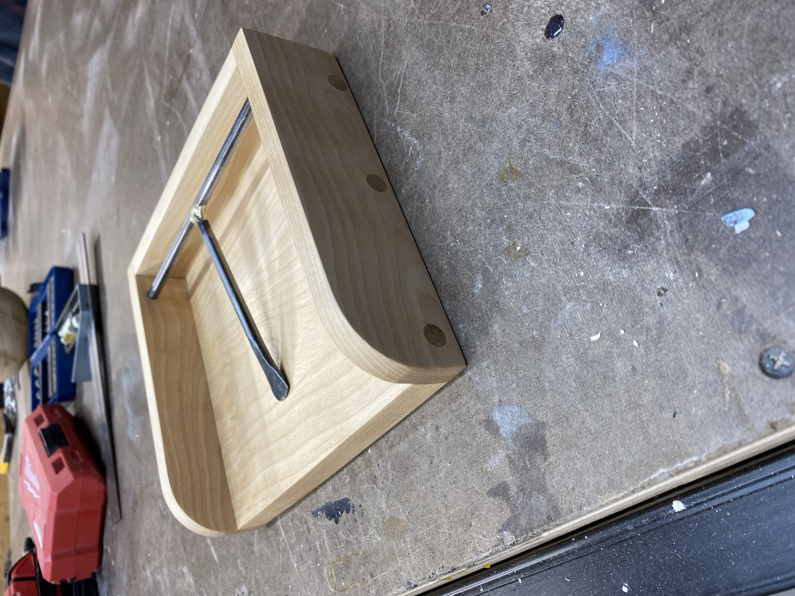 Napkin holder showing wood tray with forged metal crossbar