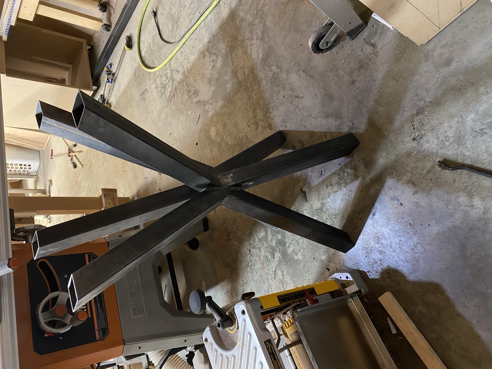 Welded steel base with splayed legs and compound angle joints