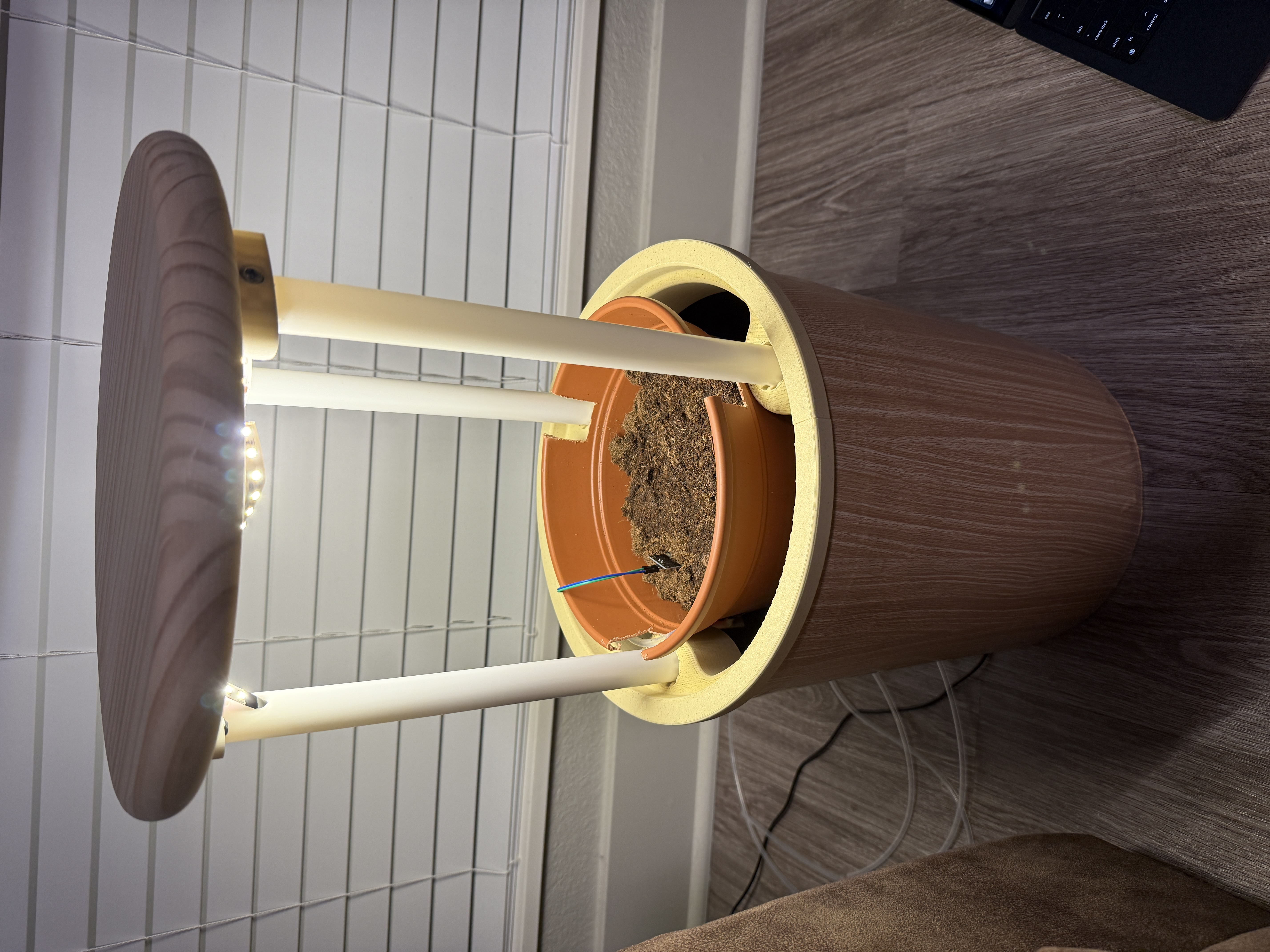 Side table home garden prototype with lid raised showing grow lights, planter pot, and wood-wrapped bucket form factor