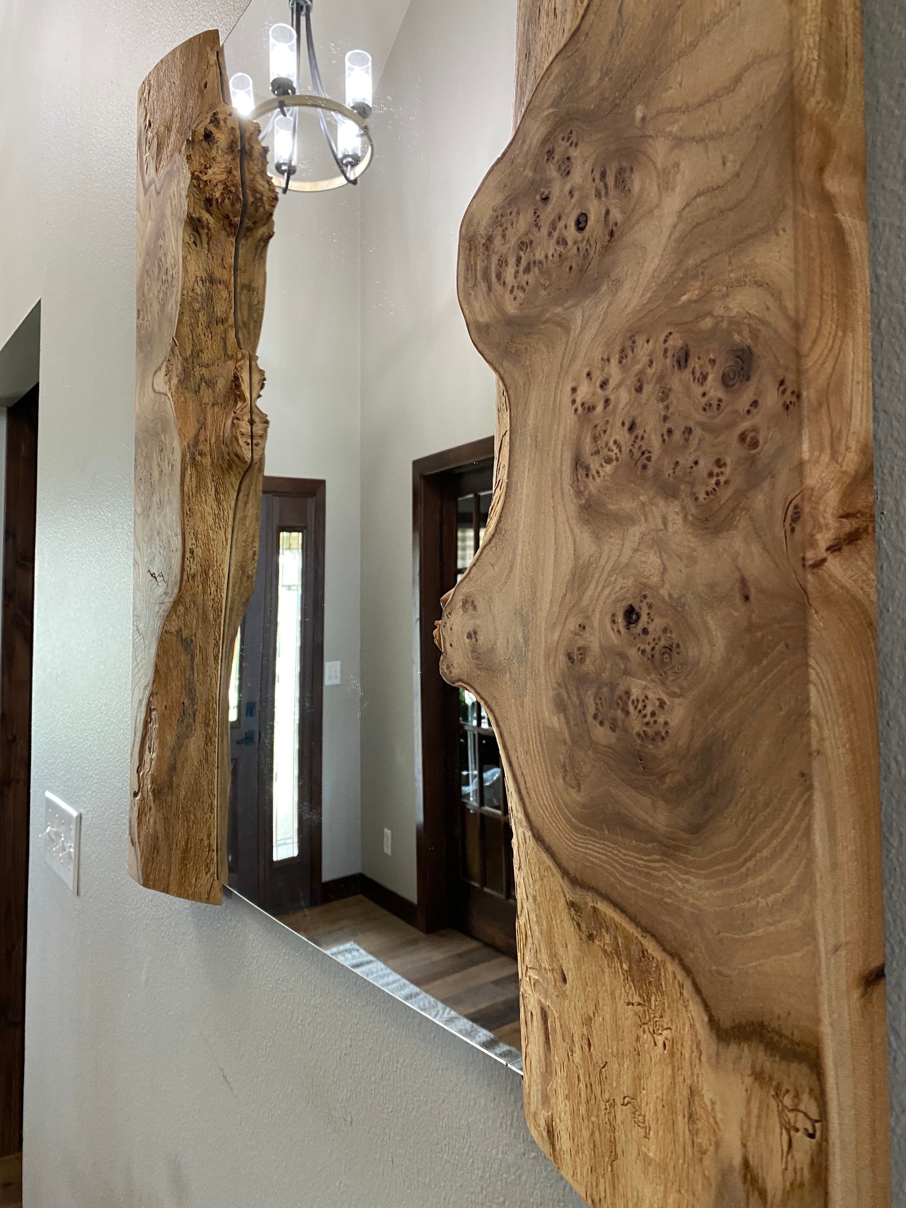 Close-up of the live edge and burl figuring where the wood meets the mirror glass