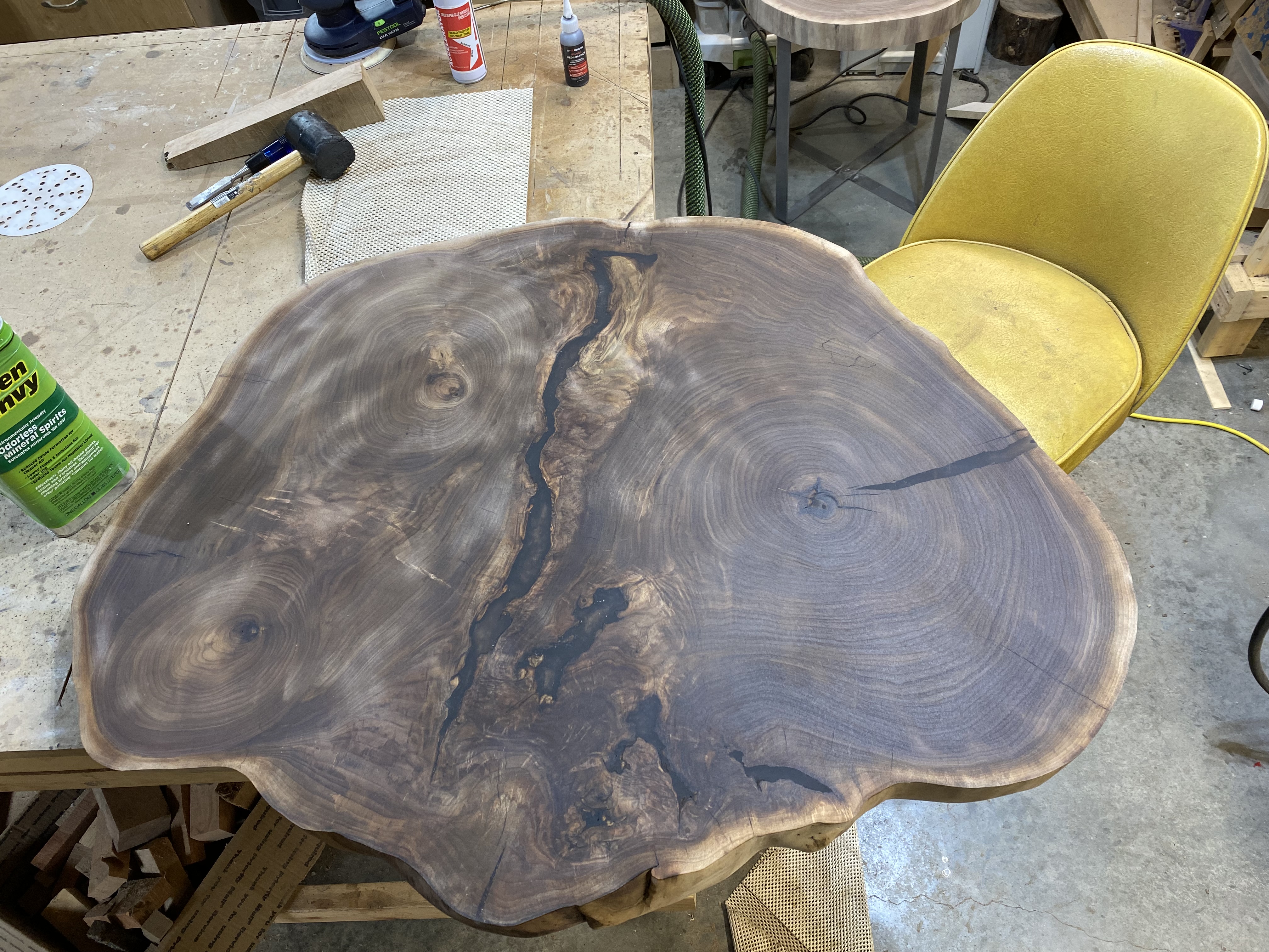 Coffee table slab after epoxy void fill and initial flattening, showing the crack detail