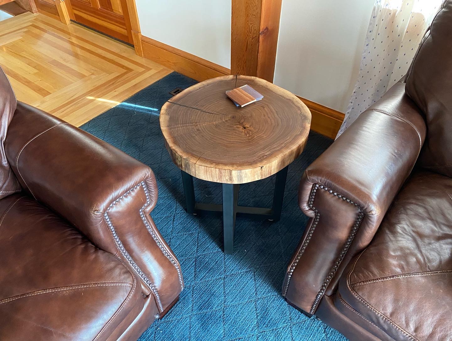 Finished end table between two leather chairs