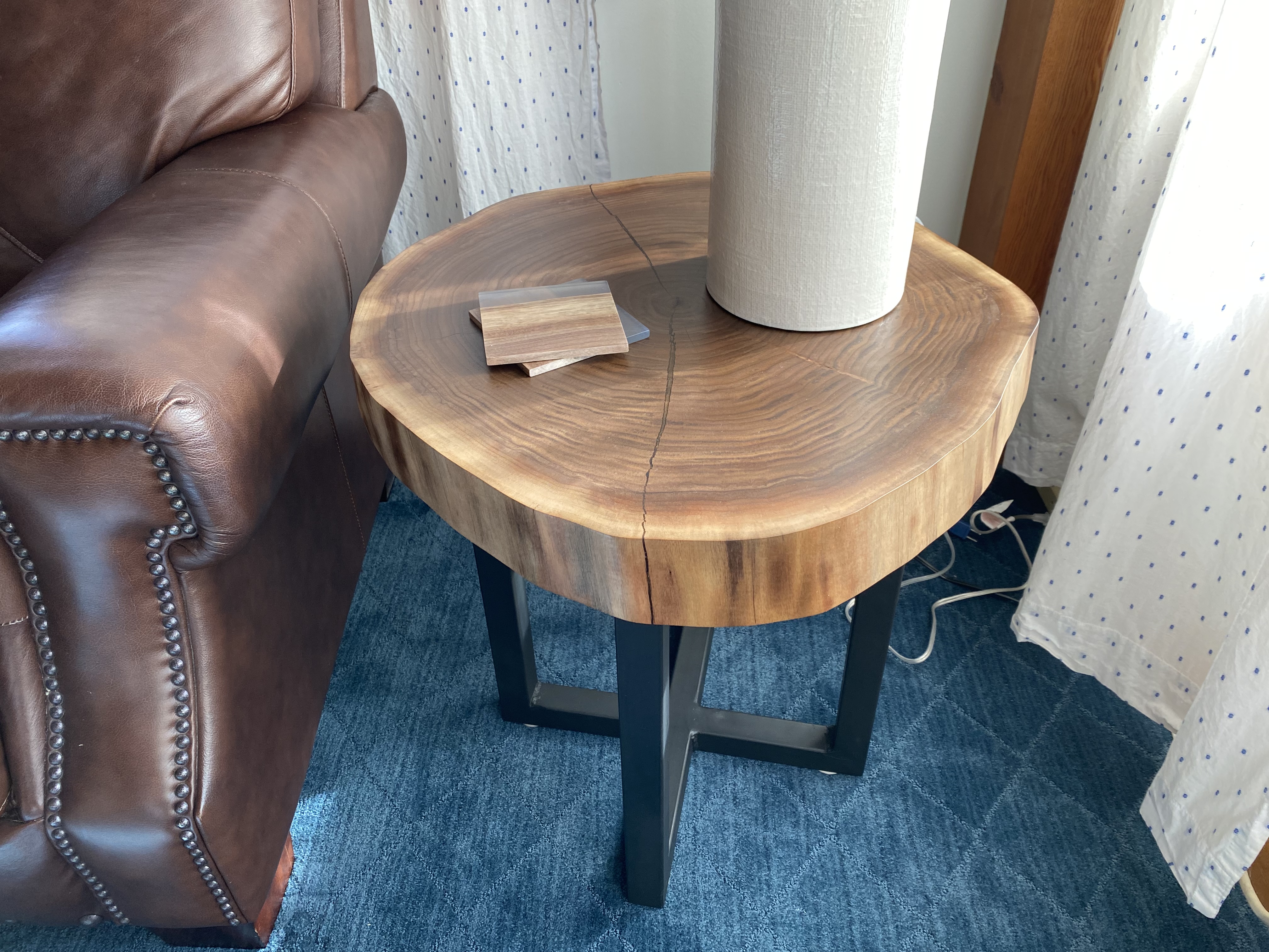Close-up of the walnut end table showing cookie slab grain and live edge